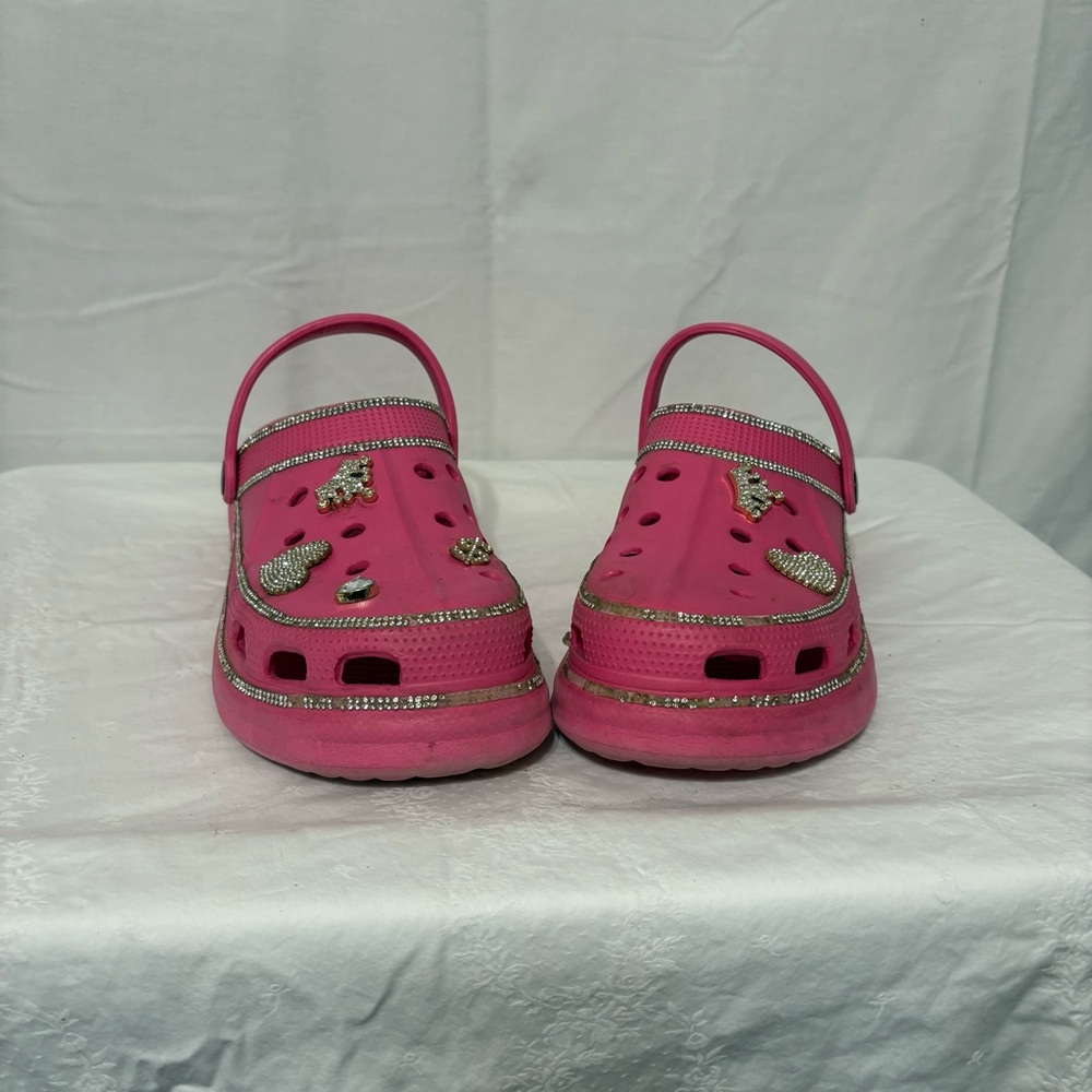 Crocs Classic Clogs in pink with assorted Jibbitz charms. Size 10/10.5